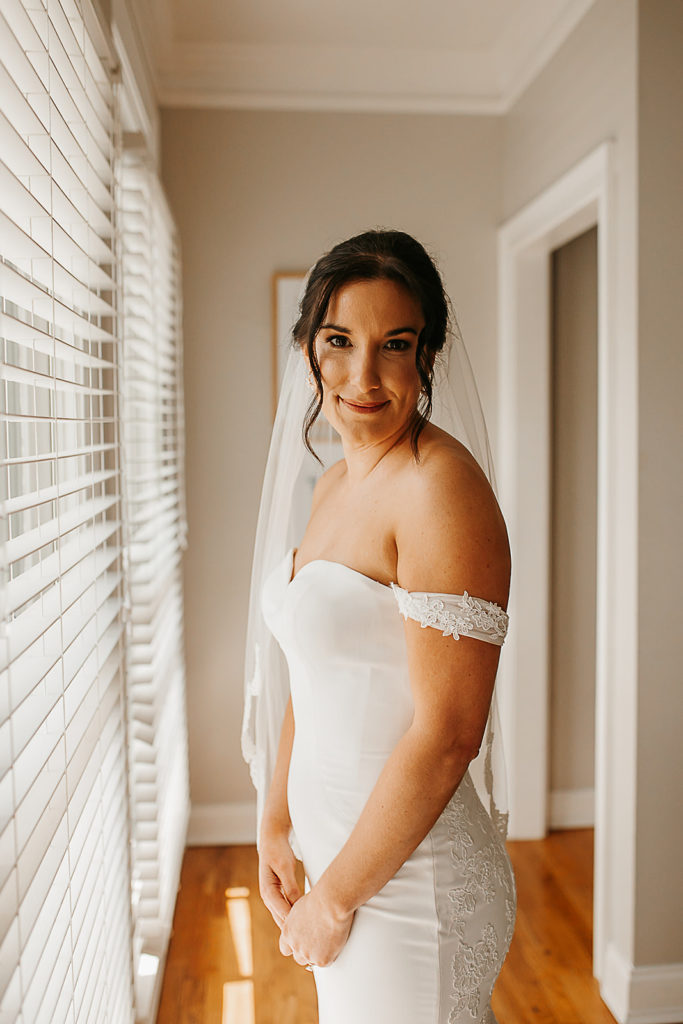 bride getting ready near window photo
