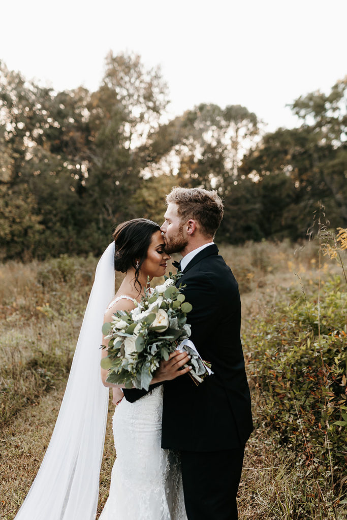 Groom kissing brides forehead for wedding in GA photoshoot